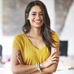 Smiling woman with arms crossed in startup office