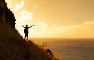 Young happy male backpacker celebrating natures beauty (location Hawaii).